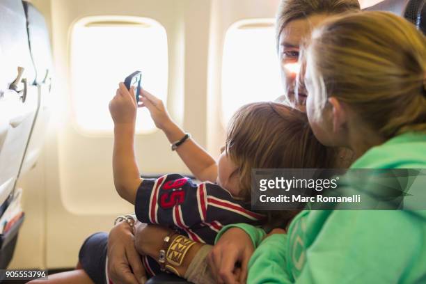 caucasian family sitting on airplane - auf dem schoß stock-fotos und bilder