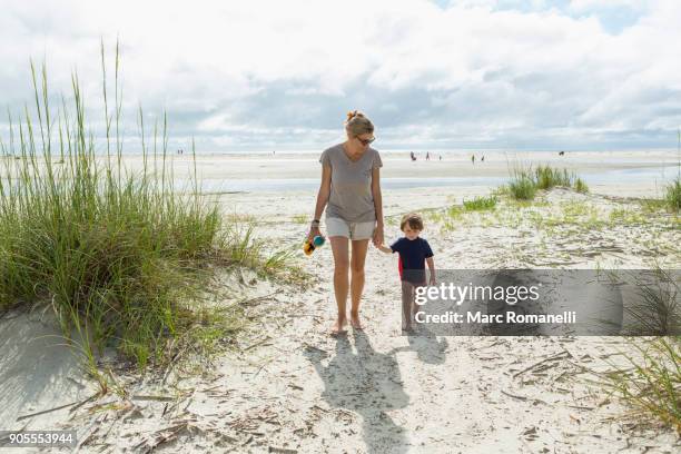 caucasian mother and son walking on beach - st simons island stock pictures, royalty-free photos & images