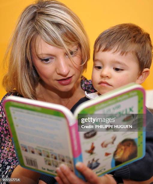 Une jeune femme lit un livre à son fils Noah, âgé de 2 ans, le 27 septembre 2008 à Houplines. "Il y a vingt ans, on était pris pour des fous, mais on...