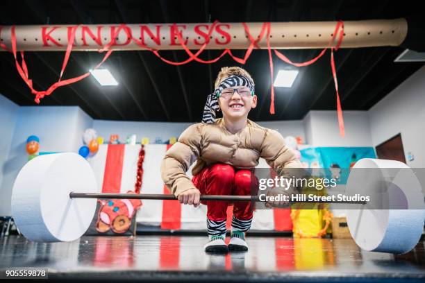 caucasian boy in strongman costume lifting toy barbell - young kid and barbell stock pictures, royalty-free photos & images