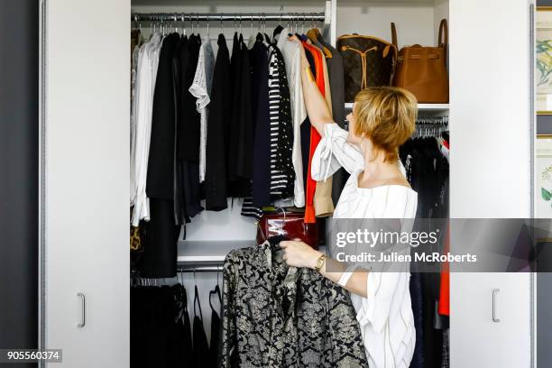 caucasian woman hanging clothes in closet - wardrobe organisation stock pictures, royalty-free photos & images