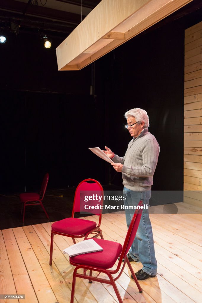 Hispanic Man Reading Script On Theater Stage Photo - Getty Images
