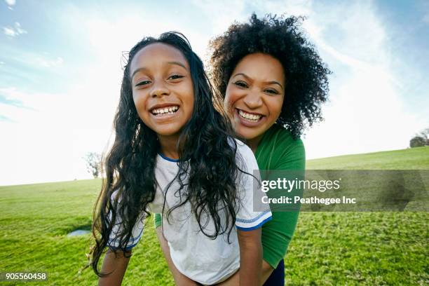 portrait of smiling mixed raced mother and daughter - mixed race stock-fotos und bilder