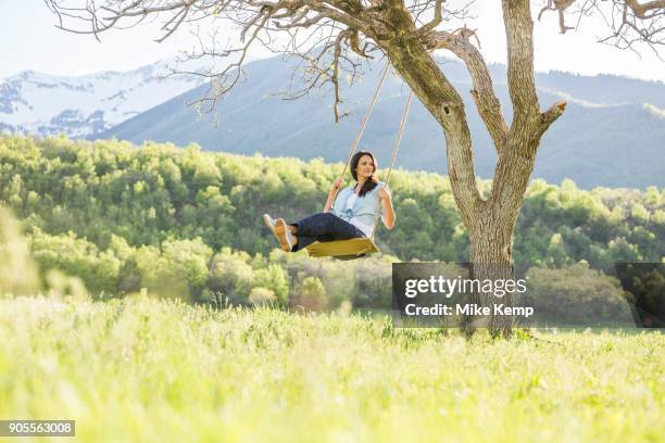 caucasian woman swinging on tree swing - oak tree swing stock pictures, royalty-free photos & images