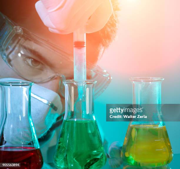 caucasian scientist experimenting with multicolor liquids - needle plant part stock pictures, royalty-free photos & images