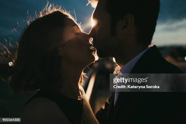 caucasian couple kissing at night - bisous photos et images de collection