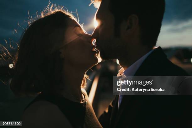 caucasian couple kissing at night - peck stock pictures, royalty-free photos & images