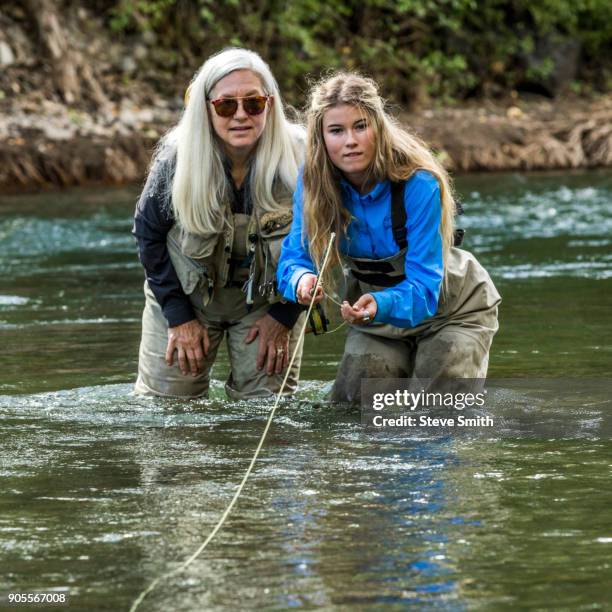 caucasian mother and daughter fly fishing - waders imagens e fotografias de stock