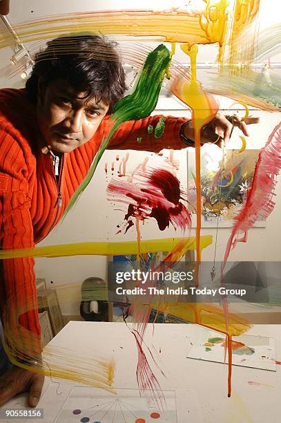 Painter Niladri Paul displays the process of colour therapy using a pendulum in New Delhi, India