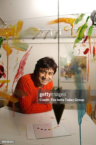 Painter Niladri Paul displays the process of colour therapy using a pendulum in New Delhi, India