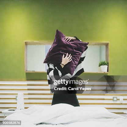 Young woman covering face with cushion Young woman covering face with cushion