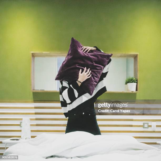 young woman covering face with cushion - pillow over head 個照片及圖片檔