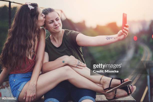 female couple kissing and making selfies. - white dragon tattoo stock pictures, royalty-free photos & images