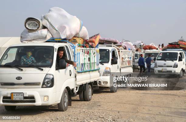 Displaced Iraqis, who fled from Hawija to Kirkuk due to battles against the Islamic State group, ride in vehicles on January 16, 2018 as they leave a...