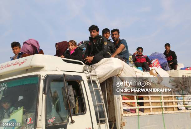 Displaced Iraqis, who fled from Hawija to Kirkuk due to battles against the Islamic State group, ride in vehicles on January 16, 2018 as they leave a...