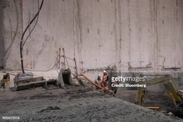 Construction workers carry out cement reinforcement work inside a tunnel during a tour of the Paris Metro subway railway line 12 Grand Paris...