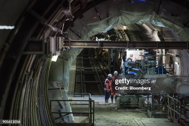 Construction workers stand beside a cherry picker inside a tunnel during a tour of the Paris Metro subway railway line 12 Grand Paris expansion...