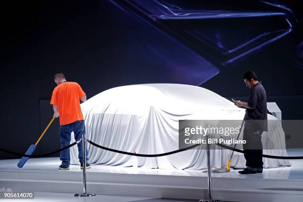 Workers clean the GAC Motors exhibit at the 2018 North American International Auto Show January 16, 2018 in Detroit, Michigan. More than 5,100...