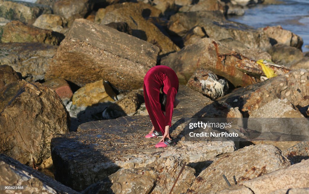 A Palestinian girl 10 y.o. demonstrates acrobatics skills on a beach in Gaza