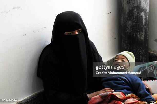 Yemeni mother carries her malnourished child while he receives medical treatment at a malnutrition center amid increasing threats of health collapse...