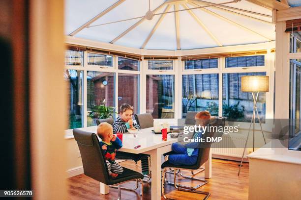 tre ragazzi che colazione a tavola - veranda foto e immagini stock