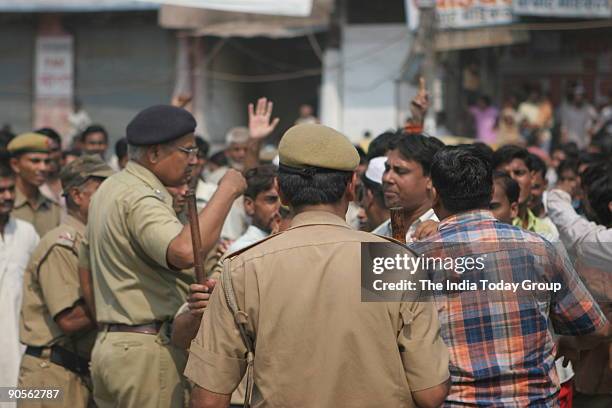 Policemen keep eye on protesters to control law and order during a demonstration by traders and shopkeepers against a Supreme Court order to close...