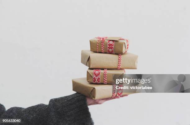 woman holding a stack of wrapped christmas gifts - pile of gifts stock pictures, royalty-free photos & images