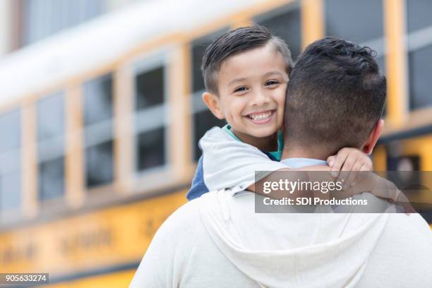 schoolboy greets father after first day - school bus kids stock pictures, royalty-free photos & images