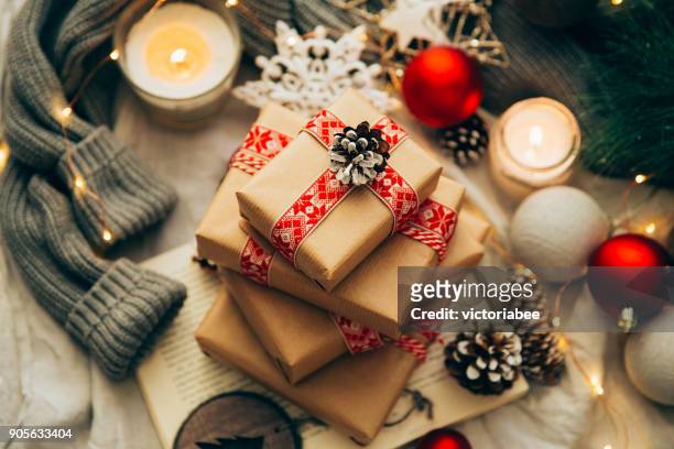 stack of christmas gifts, decorations and knitted sweater - christmas candles stockfoto's en -beelden