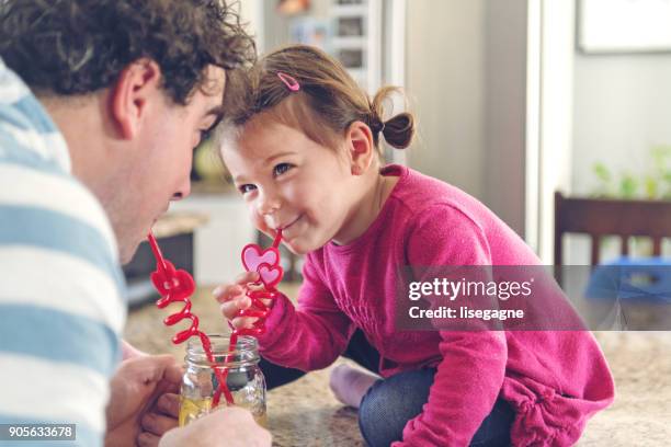 father and daughter sharing a lemonade - valentine's day home stock pictures, royalty-free photos & images