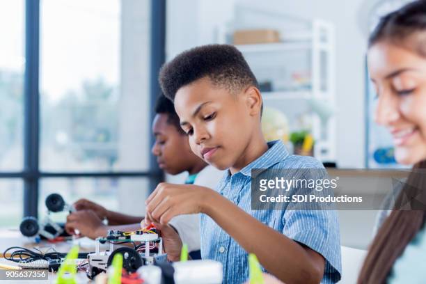 preteen boy works on robotics project at school - preteen girl models stock pictures, royalty-free photos & images