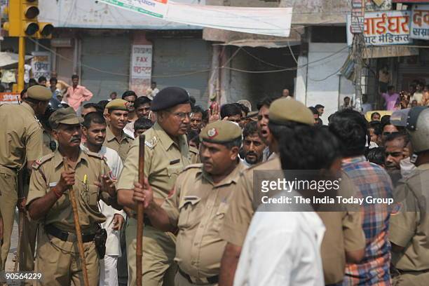 Policemen keep eye on protesters to control law and order during a demonstration by traders and shopkeepers against a Supreme Court order to close...