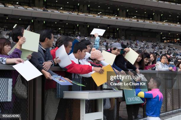 Jockey Christophe Lemaire gives his autograph to Japanese racing fans at Tokyo Racecourse on October 17, 2015 in Tokyo, Japan.