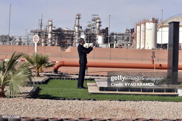 Picture taken on January 16, 2018 at In Amenas gas plant 300 kilometres southeast of Algiers, shows a worker taking a photo of a black marble...