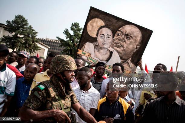 Supporters of the current President of the Democratic Republic of the Congo hold a sign during celebrations marking the 17th anniversary of the...