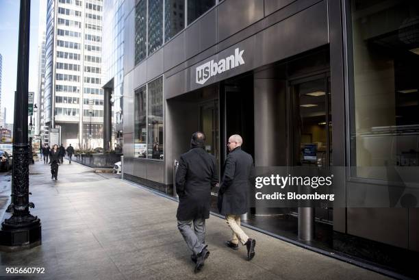 Pedestrians pass in front of a US Bancorp branch in downtown Chicago, Illinois, U.S., on Tuesday, Jan. 9, 2018. US Bancorp is scheduled to release...