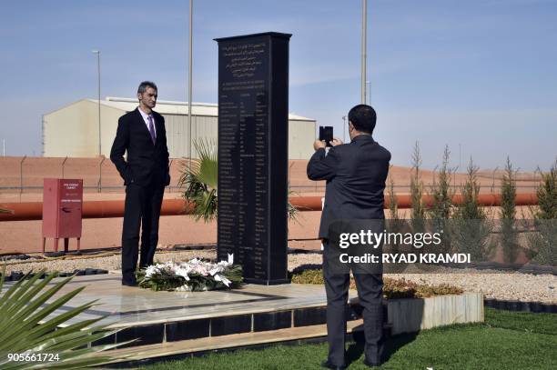 Picture taken on January 16, 2018 at In Amenas gas plant 300 kilometres southeast of Algiers, shows a man taking a photo of man standing next to a...