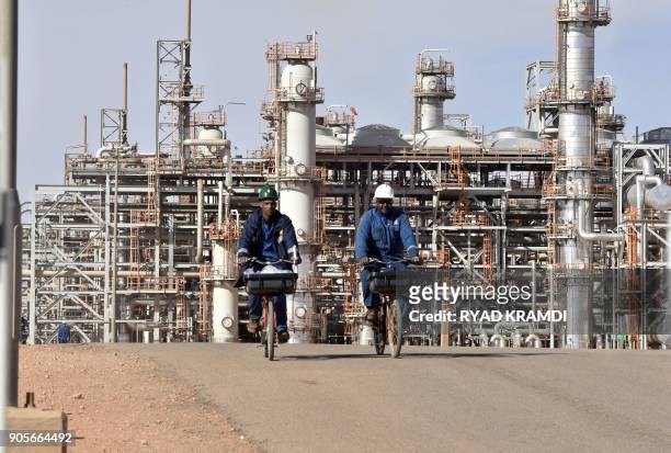 Picture taken on January 16, 2018 at In Amenas gas plant 300 kilometres southeast of Algiers, shows workers riding bikes following a ceremony to mark...