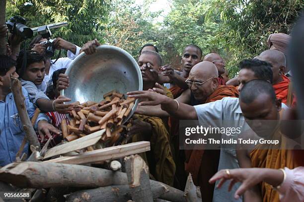 Bahujan Samaj Party workers and Buddhist monks pay last respect to Kanshi Ram's funeral pyre, founder of BSP, at Nigambodh Ghat, New Delhi, India....