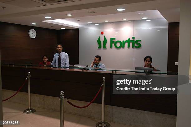 Doctor speaks to a patient as others wait in the preventive care lounge at Fortis Hospital.