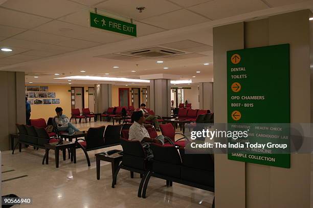 Doctor speaks to a patient as others wait in the preventive care lounge at Fortis Hospital.