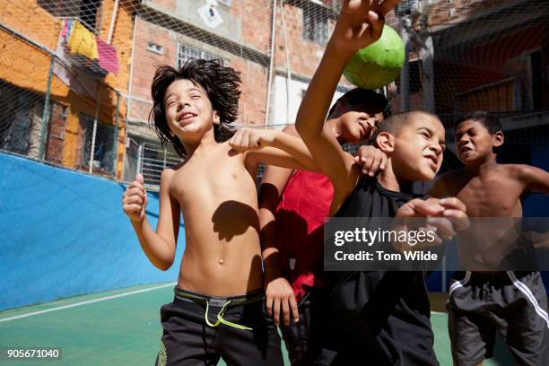 group of young boys playing football outdoors - brazilian playing football fotografías e imágenes de stock