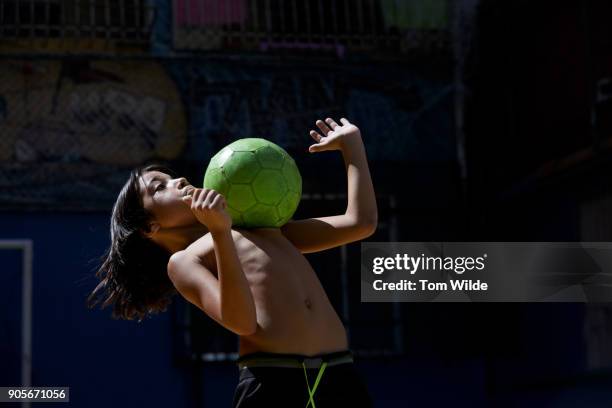 boy plays football with a green ball - football favelas stock pictures, royalty-free photos & images
