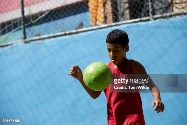 boy playing football/soccer - brazilian playing football stock-fotos und bilder