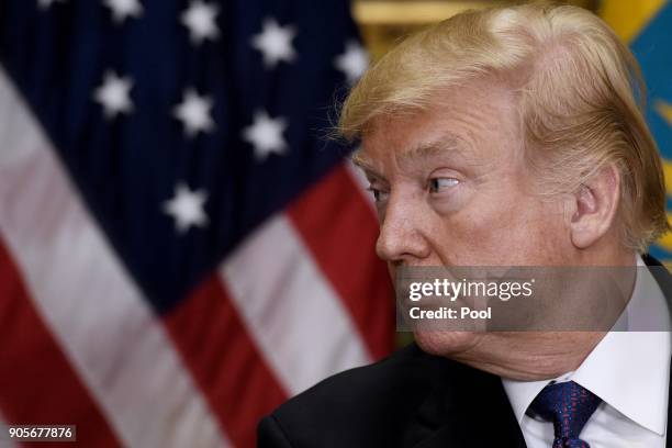 President Donald Trump listens to President Nursultan Nazarbayev of Kazakhstan during a joint press conference in the Roosevelt Room of the White...