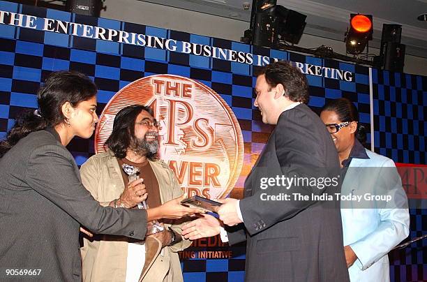 Jeh Wadia, Managing Director of GoAir, receiving an award from Prahlad Kakkar with Arindam Chaudhuri, Indian economist and management consultant in...