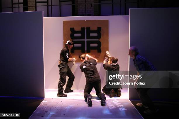 Workers install the logo ahead of the Riani show during the MBFW January 2018 at ewerk on January 16, 2018 in Berlin, Germany.