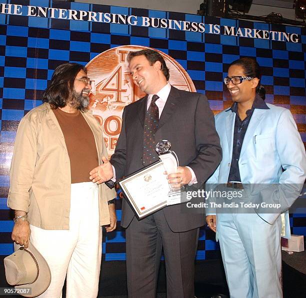 Jeh Wadia, Managing Director of GoAir, receiving an award from Prahlad Kakkar with Arindam Chaudhuri, Indian economist and management consultant in...