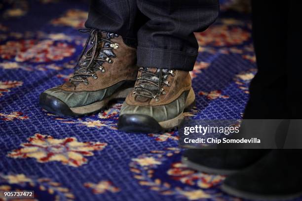 Sen. Rand Paul wears winter boots during a news conference about proposed reforms to the Foreign Intelligence Surveillance Act in the Russell Senate...
