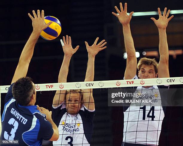 Mauro Gavotto of Italy spikes the ball over the net blocked by Finland's Mikko Esko and Konstantin Shumov during their European Volleyball...